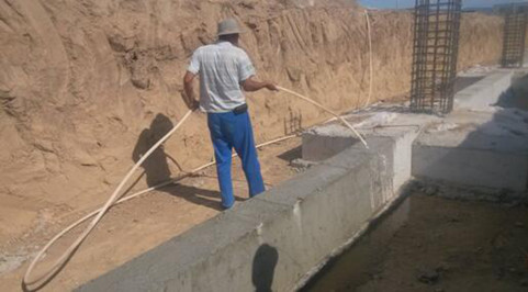 正在浇水养护混凝土的施工人员