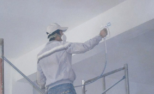 正在房子里喷墙漆的工人